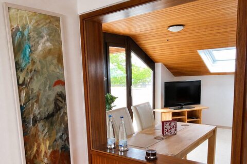 Living and dining area with TV seen through an interior window